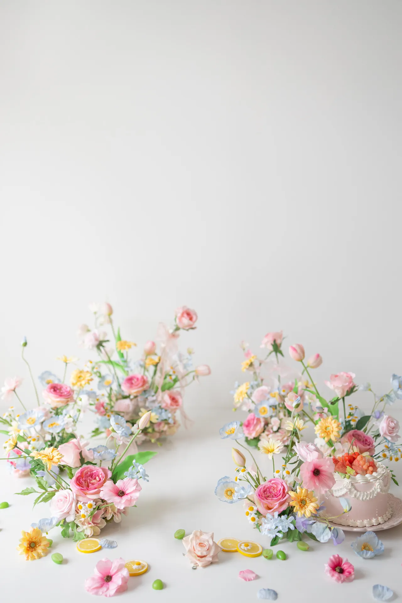 白い背景に、色とりどりの花を飾ったセットの写真