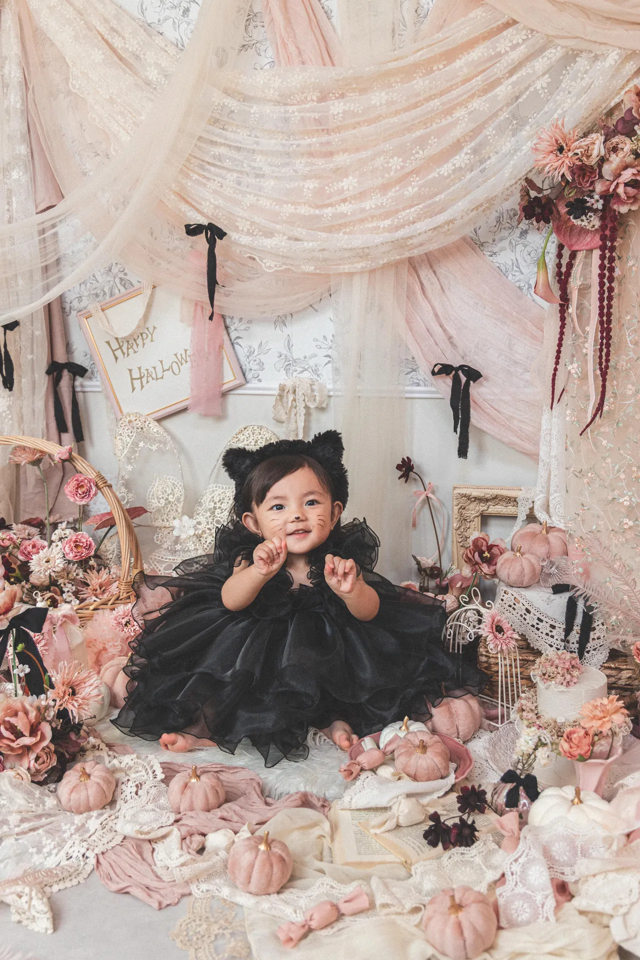 淡いピンクのセットで、黒いドレスの女の子が座っている写真